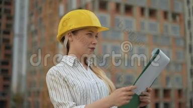 女青年工头将正在建造的建筑物的平面图与实物4K相比较